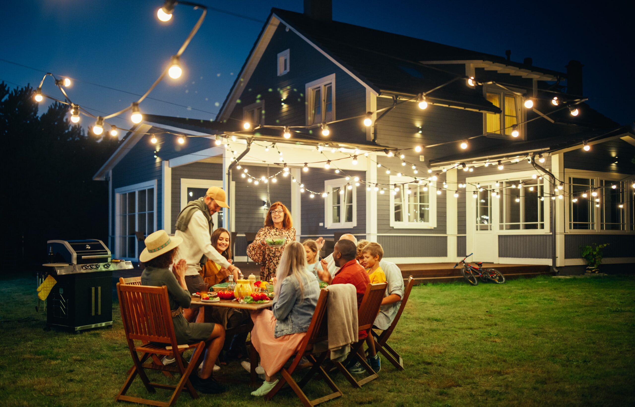 family sitting outside enjoying dinner on a summer night